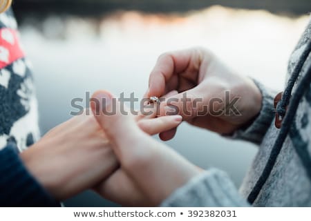 Stock fotó: Man Putting Engagement Ring On Finger