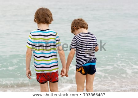 Foto d'archivio: Cute Boy Has Fun In The Stormy Beach