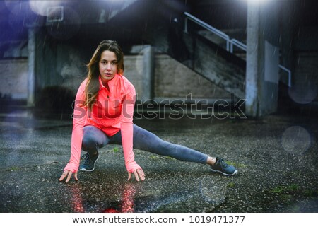 Foto stock: Young Urban Fitness Woman Stretching Adductors