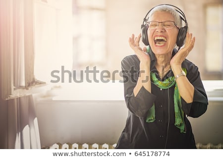 ストックフォト: Senior Woman In Headphones Listening To Music