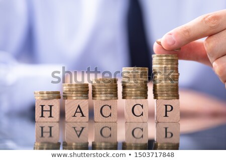 Stock photo: Man Stacking Coins On Haccp Letters