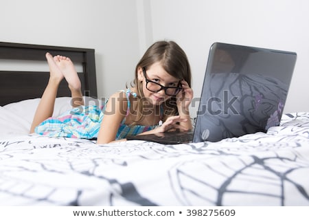 Foto d'archivio: Nine Years Old Child Having Fun Using Laptop At Her Bedroom