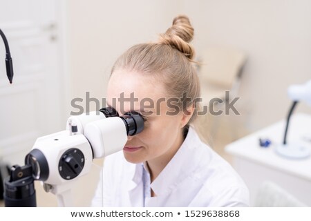 Zdjęcia stock: Young Pretty Eye Doctor Looking Through Optometric Equipment