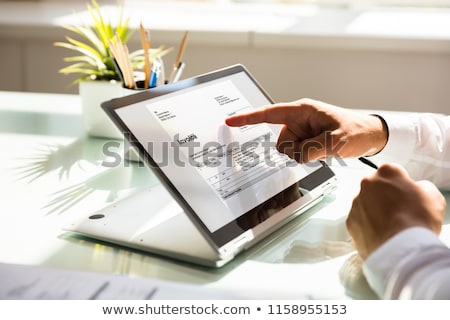 Stock photo: Person Calculating Invoice On Desk