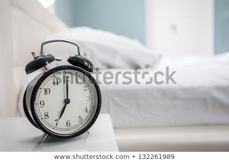 Foto d'archivio: Alarm Clock On Bed Sheets