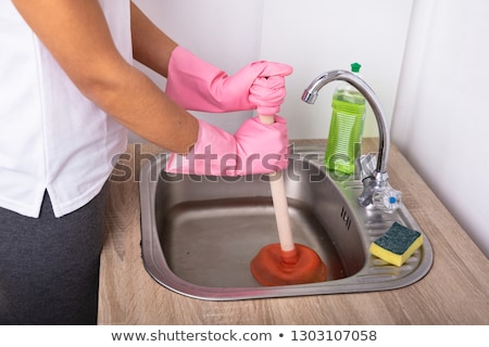 Foto stock: Close Up Of Woman Using Plunger In Sink