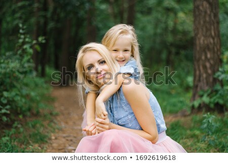 Stok fotoğraf: Little Girl Kissing Her Mum In Woods