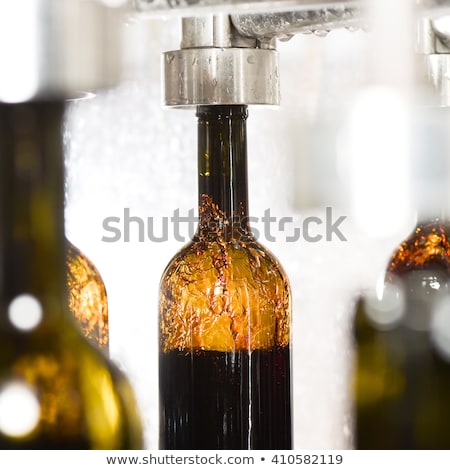 [[stock_photo]]: Wine Bottle Filling Along Conveyor Belt In Bottling Factory