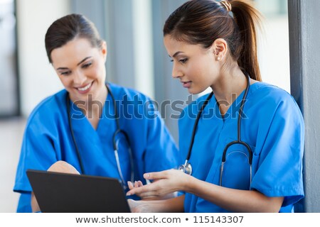 Foto stock: Cheerful Young Nurse With Stethoscope Pointing