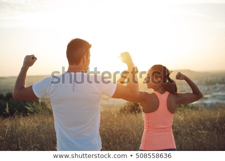 Stock photo: Couple Of Runners Lexing Biceps Towards The Sun