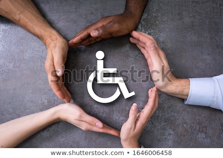 Foto stock: Hands Protecting Disabled Handicap Icon