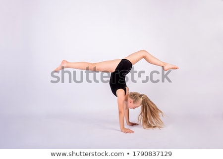 Zdjęcia stock: Girl Performs A Handstand In The Studio Isolated On Black