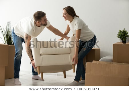 Foto stock: Young Couple Lifting Sofa