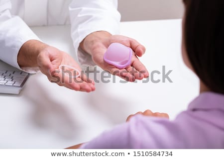 Foto stock: Gynecologist Showing Contraception Ring And Diaphragm