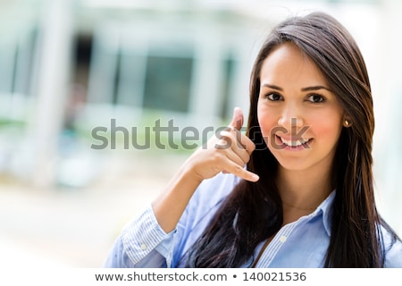 Foto stock: Woman Making A Call Me Sign Outdoors