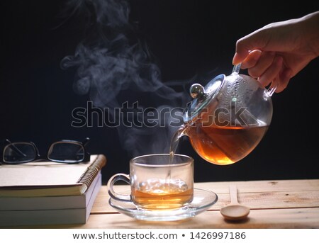 Stock fotó: Teapot Poring Green Tea Into A Cup