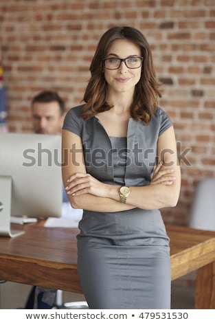 Stockfoto: Smiling Woman In Business Clothes And Eyeglasses With Crossed Arms