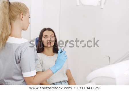 Stock photo: Woman Is Scared Of The Dentist And Dental Equipment Scary Dentist Visit Concept