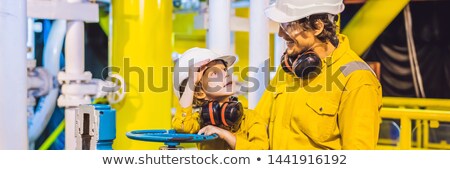 [[stock_photo]]: A Young Man And A Little Boy Are Both In A Yellow Work Uniform Glasses And Helmet In An Industrial