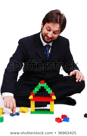 Foto d'archivio: Young Mane Wearing Suit Is Making A House With Cubes Toys