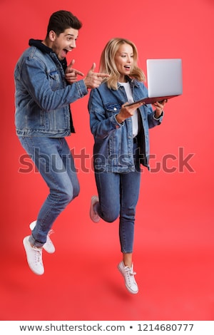 Stockfoto: Portrait Of An Excited Young Couple Dressed In Denim Jackets