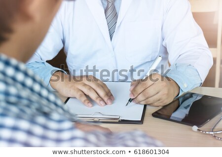 ストックフォト: A Female Doctor Taking Notes On A Clipboard