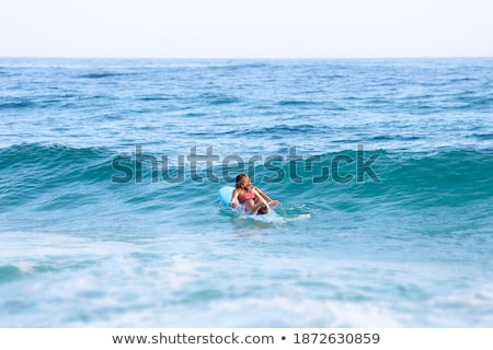 Foto d'archivio: Female Surfer Paddling On Surfboard To The Open Sea