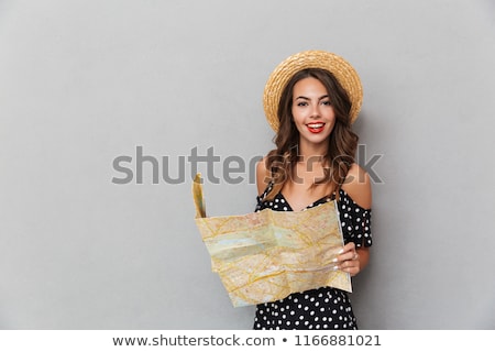 Сток-фото: Cute Woman Wearing Hat Holding Map Over Grey Wall