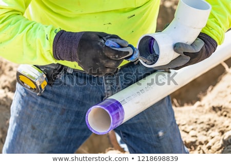 Stockfoto: Plumber Applying Pipe Cleaner Primer And Glue To Pvc Pipe At Co