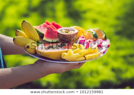 ストックフォト: Picnic At The Park On The Grass A Plate Of Tropical Fruits Against The Background Of Grass