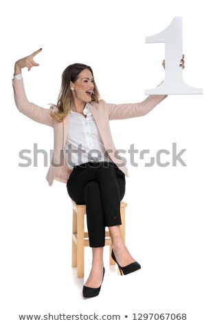 Stok fotoğraf: Happy Businesswoman Holds One And Looks To Side While Celebratin