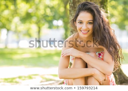 Stok fotoğraf: Attractive Brunette Young Woman With Long Wavy Hair Sitting On A