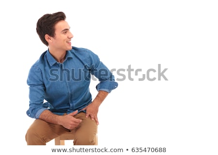 Сток-фото: Seated Casual Young Man Laughing And Looks To Side