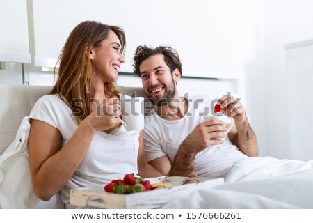 Young Beautiful Couple Eating Breakfast In Bed Zdjęcia stock © Photoroyalty