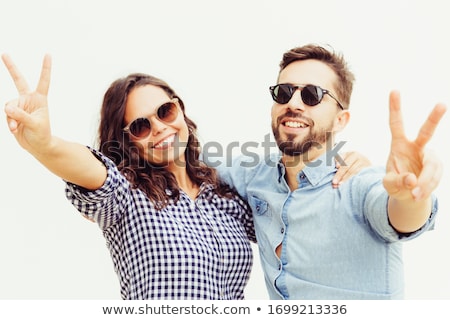 Stok fotoğraf: Young Couple Standing And Showing Victory Gesture