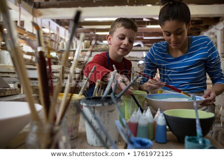 Stok fotoğraf: Female Potter And Boy Painting Bowl