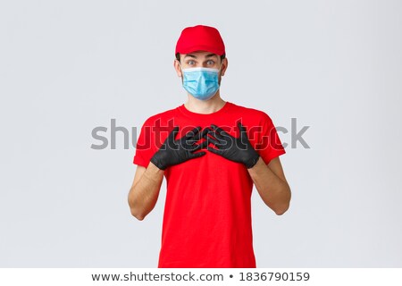 ストックフォト: Covid 19 Coronavirus Epidemic Courier Man In A Protective Medical Mask Holds A Parcel Online Orde