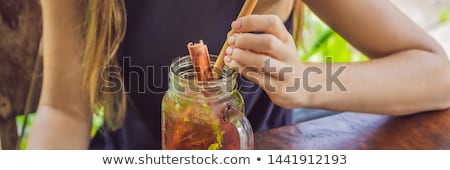 Foto d'archivio: Young Woman Drinking Cold Tea With Cinnamon In Rice Field