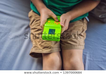 Foto stock: Young Boy Playing Old School Portable Game Console Electronic Retro Pocket Toy With Monochrome Disp