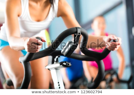 Stockfoto: Young People With Fitness Bicycle In The Gym