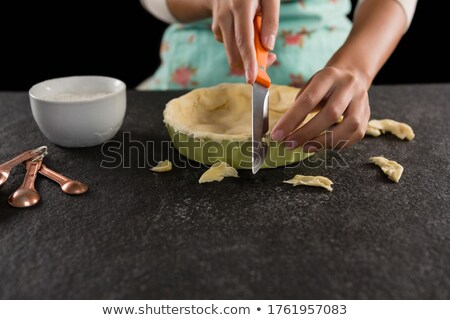 Zdjęcia stock: Woman Slicing Off Extra Dough From The Mold