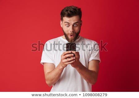 ストックフォト: Handsome Young Man Chatting By Mobile Phone Looking Aside