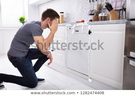 Stok fotoğraf: Upset Man Sitting In Front Of Damaged Dishwasher