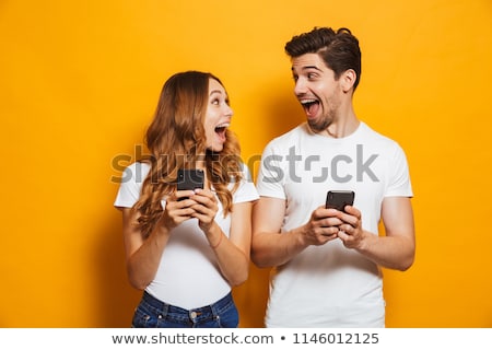 Stockfoto: Portrait Of An Excited Young Woman Using Mobile Phone