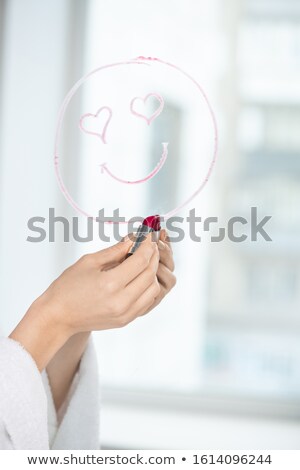 Stock fotó: Hand Of Girl With Crimson Lipstick Drawing Face With Smile And Heartshaped Eyes