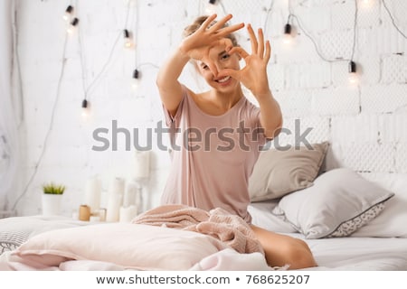 Stok fotoğraf: Happy Young Woman In Shirt Sitting On Bed