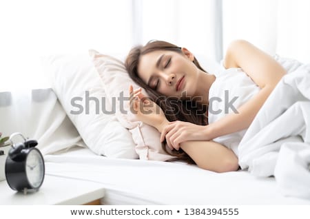 Foto stock: Brunette Woman Lies On Bed With Eyes Closed