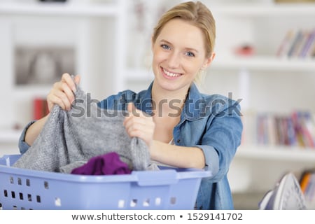 Foto d'archivio: Woman Or Housewife Sorting Laundry At Home