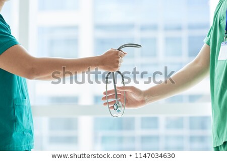 Stockfoto: Anonymous Doctors Passing Stethoscope Near Window