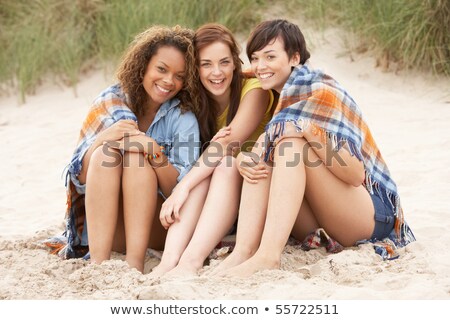 Foto stock: Res · adolescentes · sentados · juntos · en · las · dunas · de · arena